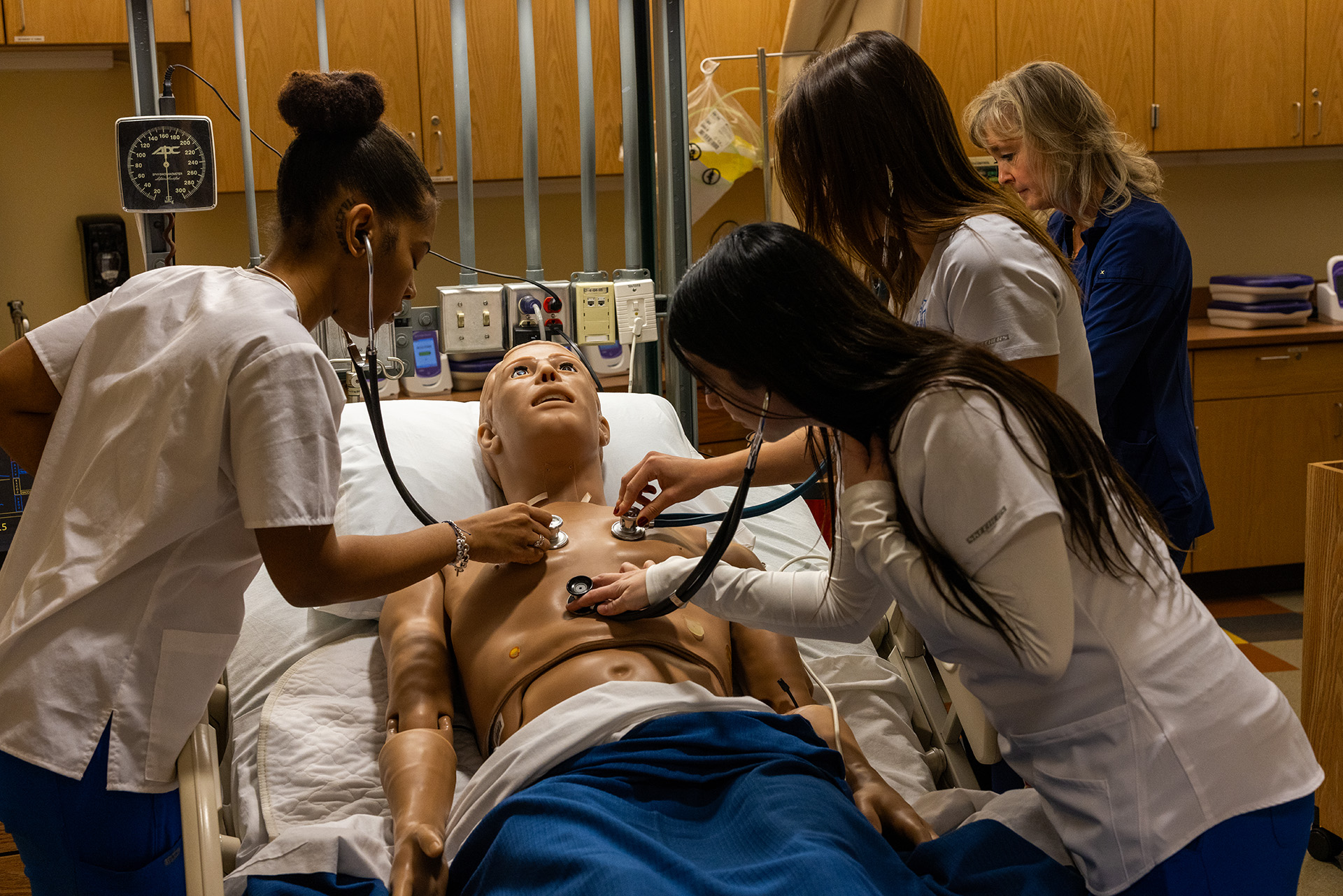 Nursing students in class listening to patient's heartbeat